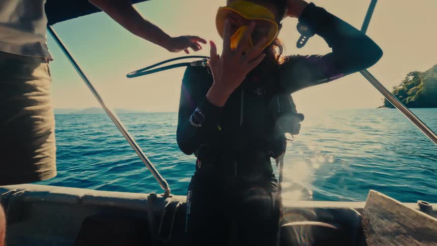 Man supports scuba diver before she falls backward into the ocean