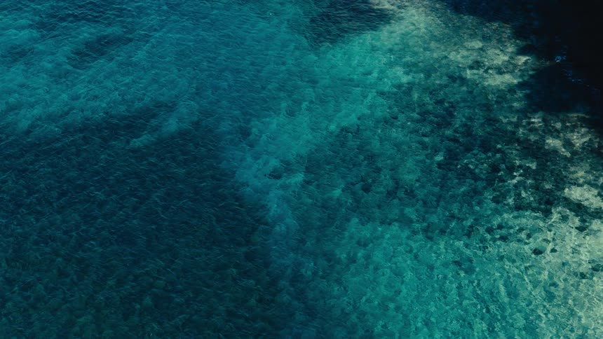 Waves flow across ocean waters crossing deeper waters then shallower water as they approach the coast