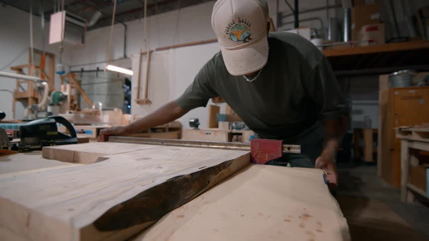 Carpenter working with wood and bending over a table