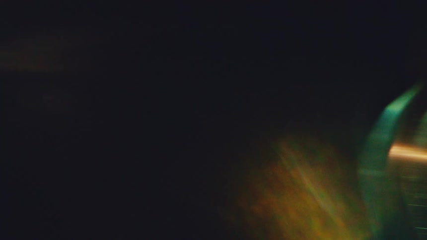 Blurred curved shapes with orange light streak over dark background