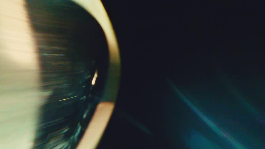 A golden ring spins rapidly at night illuminated by a bright light