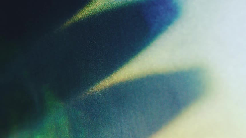 Luminous beams of light cut through a dark blue atmosphere in this abstract scene