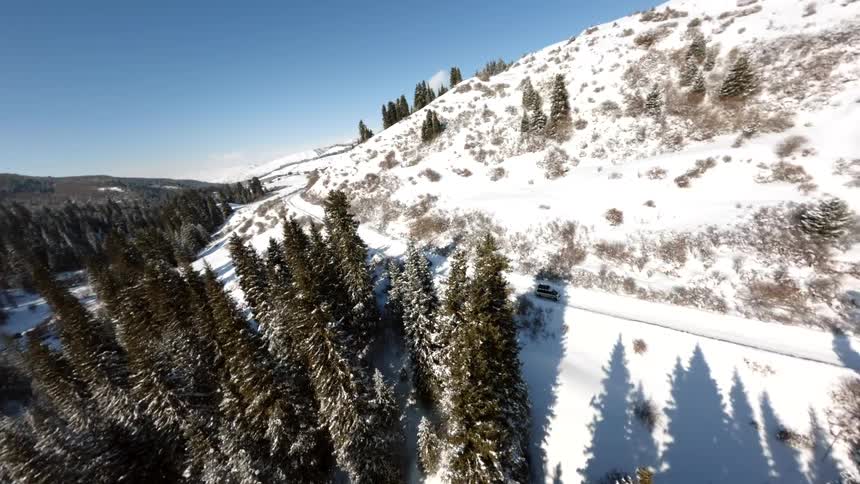 Cars are driving on the mountain road in the snow