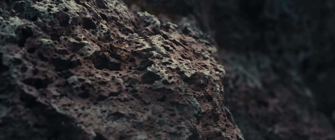Holes cover the craggy rock surface of a mountain slope during the daytime