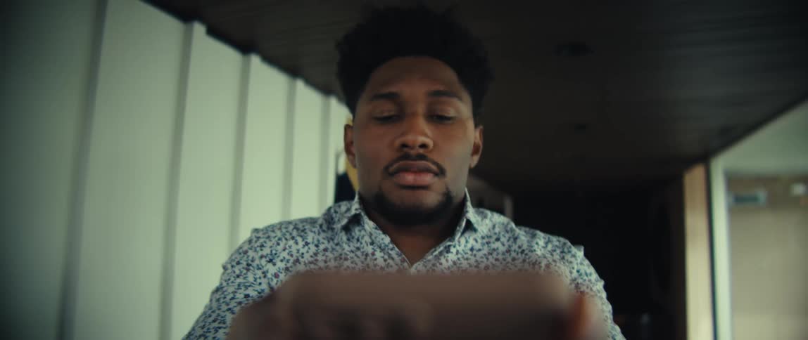 Man looking at a cellphone with a focused expression indoors