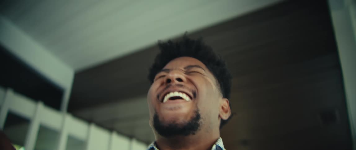 Man looking at a smartphone with a surprised expression indoors
