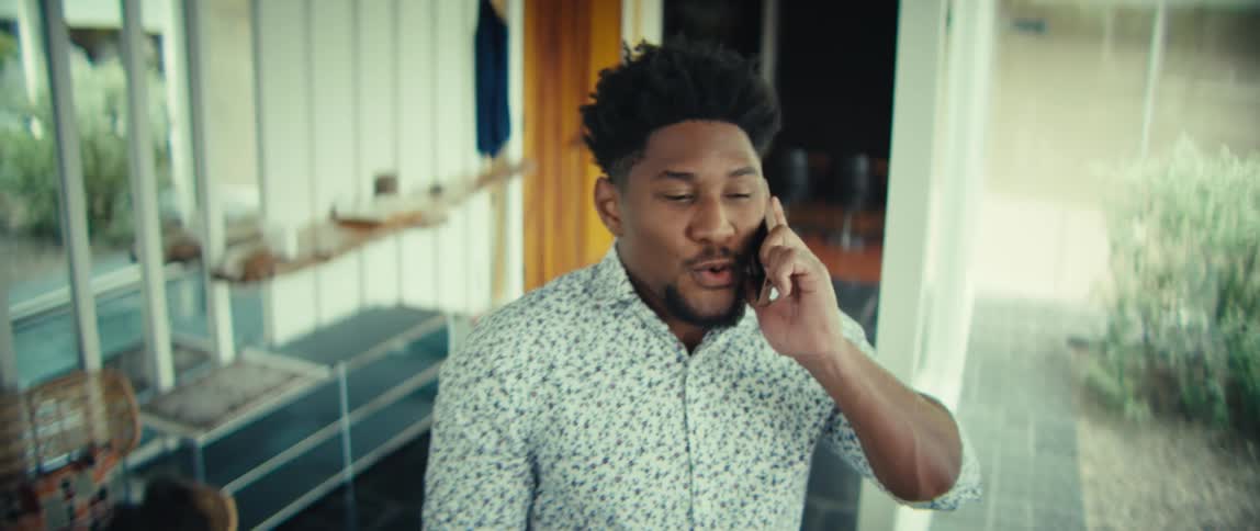 The man looks relieved while talking on his phone
