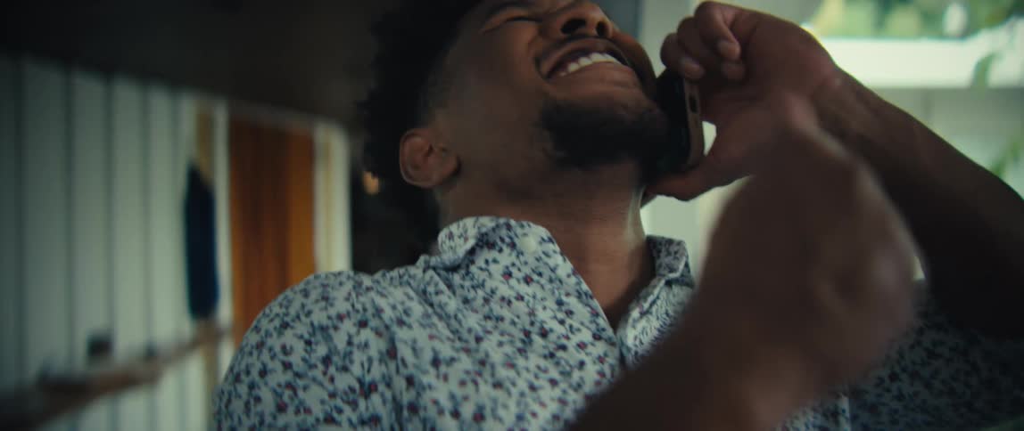 Person talking on cellphone with laughing expression