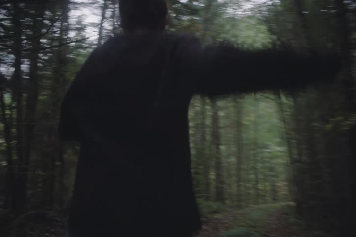 Teenage girl runs on a trail through the forested mountains