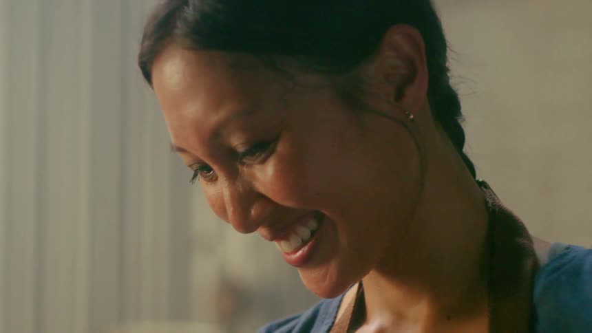 A woman smiles and looks away