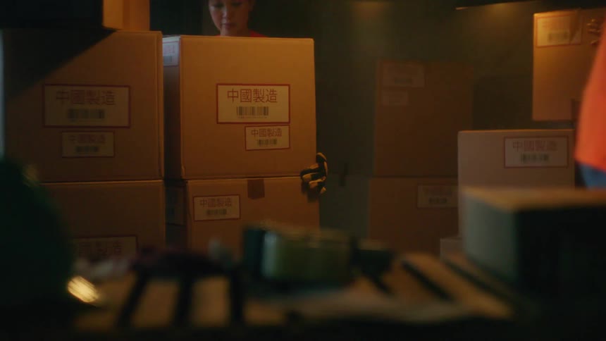 People stack boxes inside a warehouse