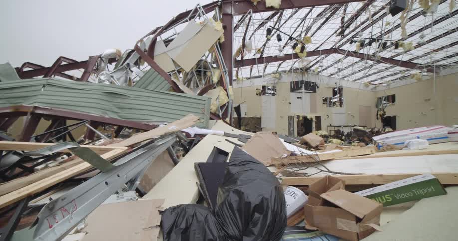 Partially destroyed building structure with exposed beams and debris scattered inside