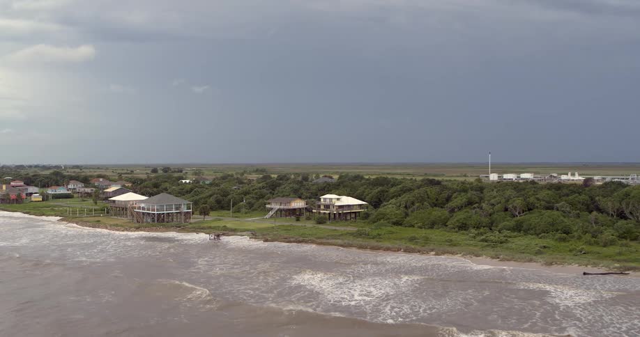 An aerial view of a coast with a storm in the distance