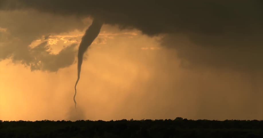 The tornado moves over the field as rain pours down