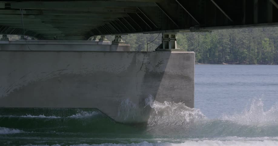 A wakeboarder jumps beneath a bridge