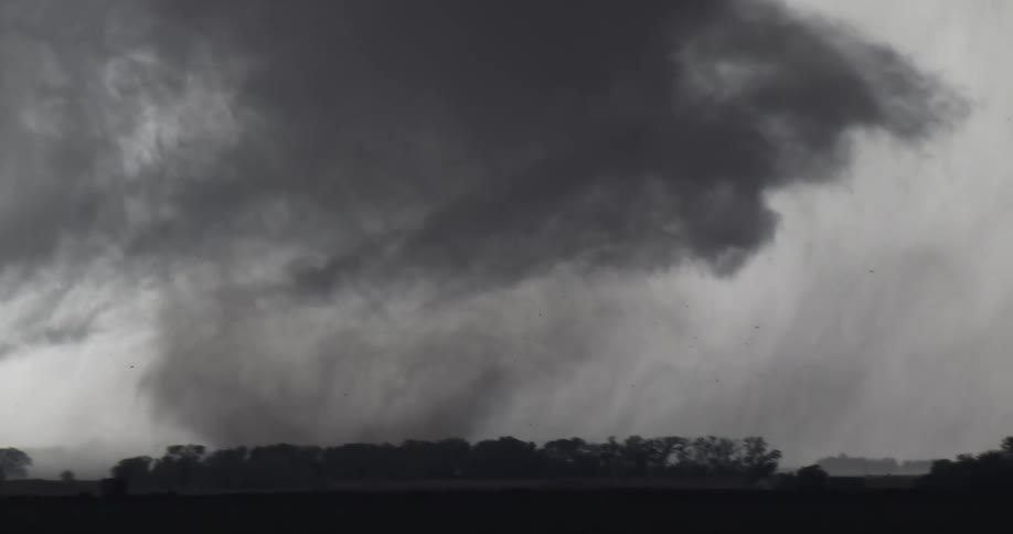 A tornado forming in the distance over some land