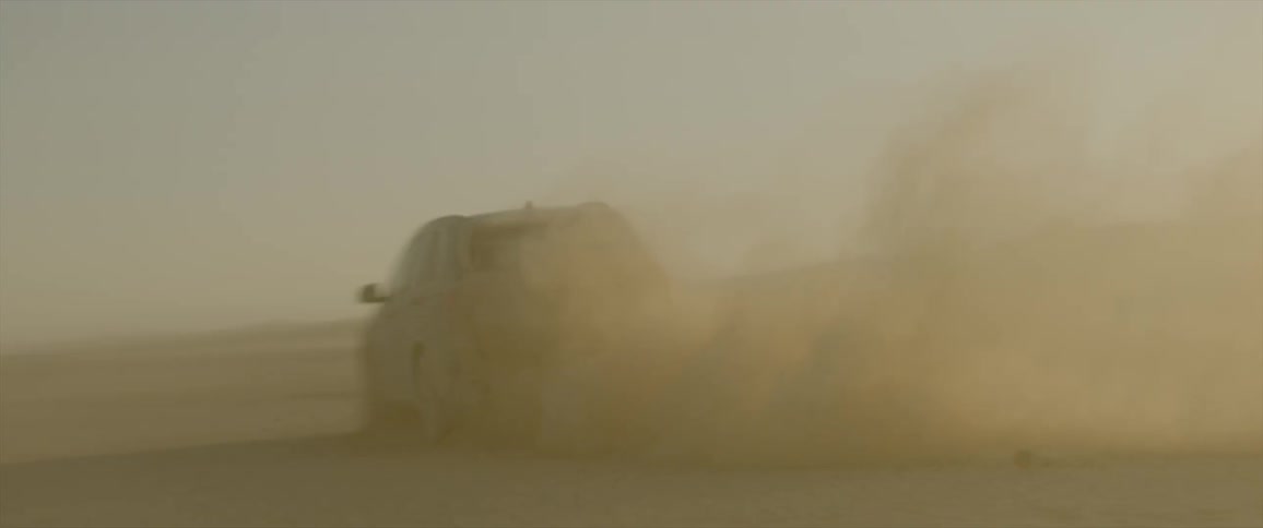 Van driving around in a dusty desert