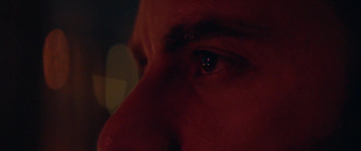 A man blinks and looks down