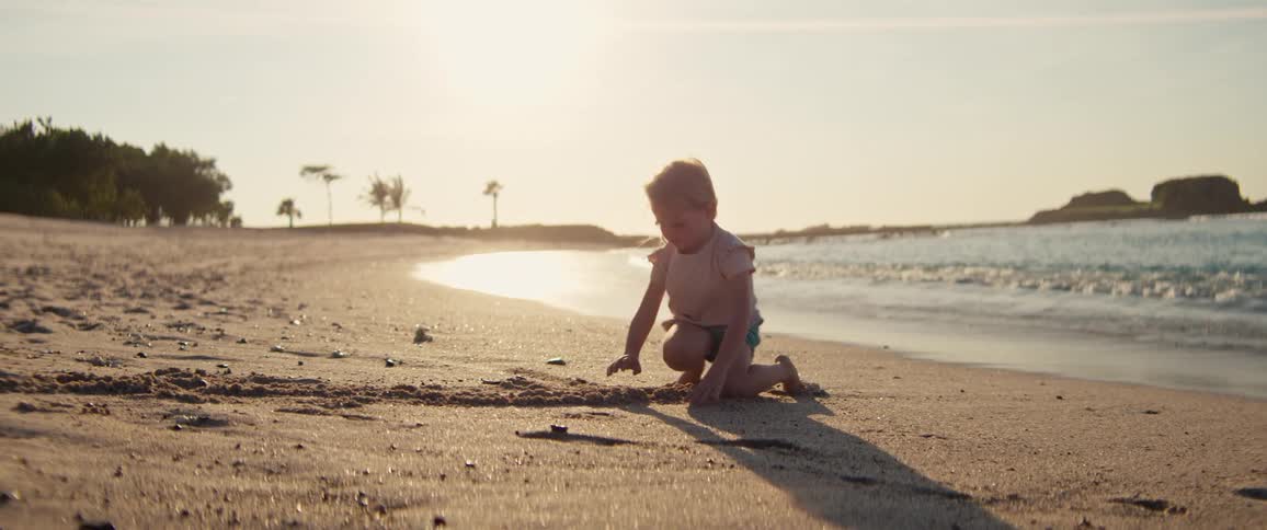 The girl is digging in the sand on the beach