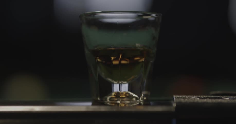 A half full shot glass on a table