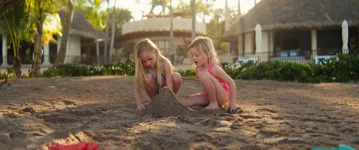 Two children building a sand castle on the beach