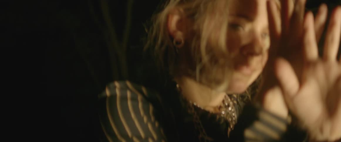 A woman dances in flashing light