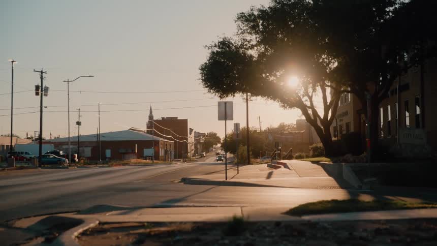 Buildings on the street of a suburban town as traffic moves in the distance