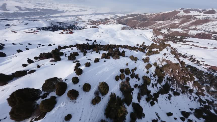 An aerial view of a mountain covered in snow and rocks