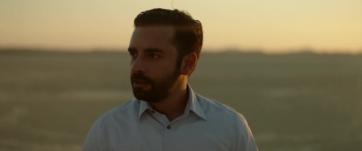 Man looks around in the middle of a sandy desert