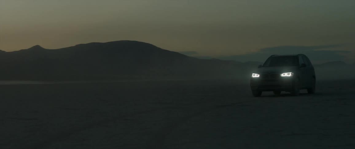 Car drives through the desert at night