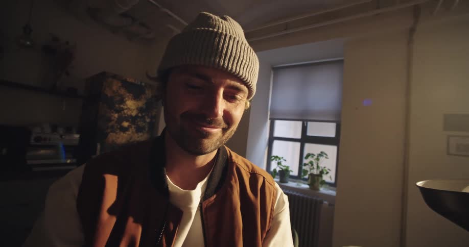 A man is smiling at his phone, receiving a notification