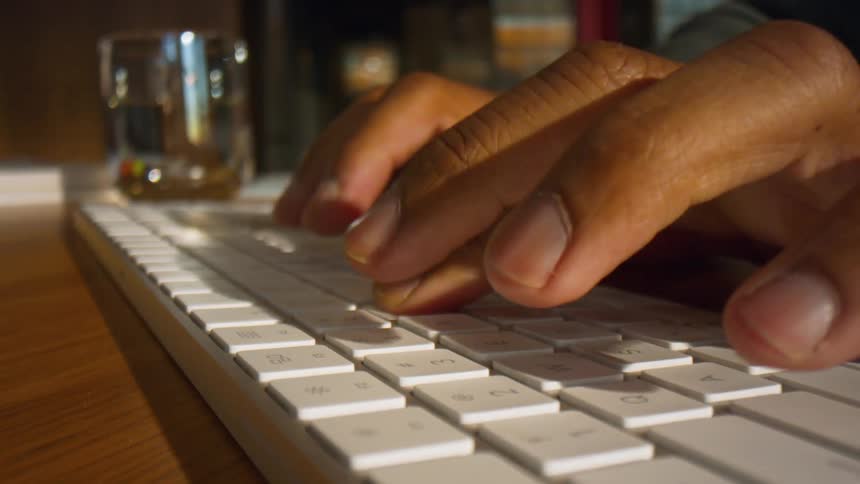 Mans fingers typing on a computer keyboard
