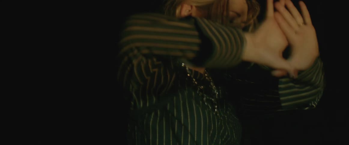A woman dances in flashing light