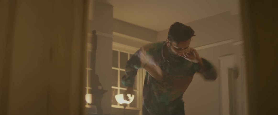 A man dances on a coffee table
