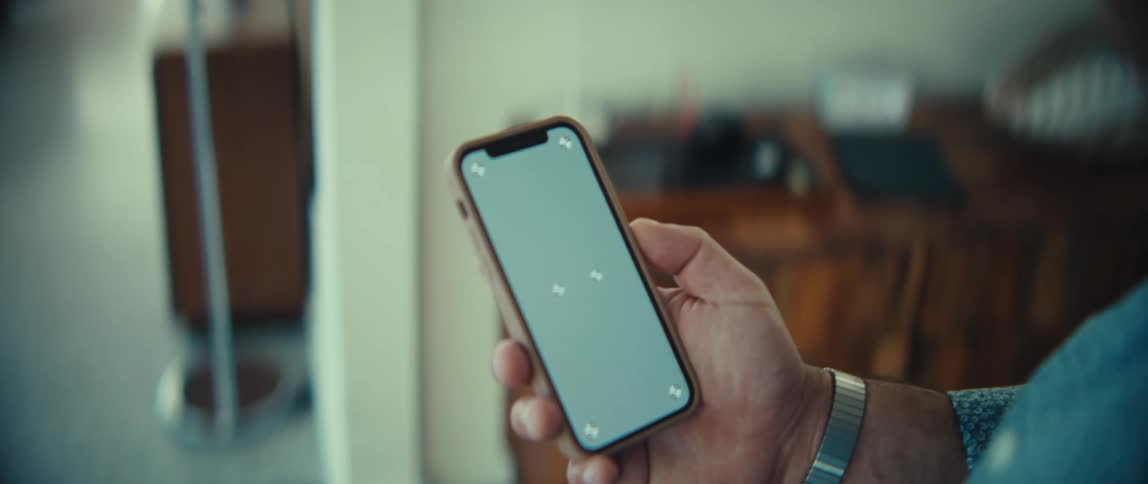 A person holds a smartphone with a green screen for screen replacement