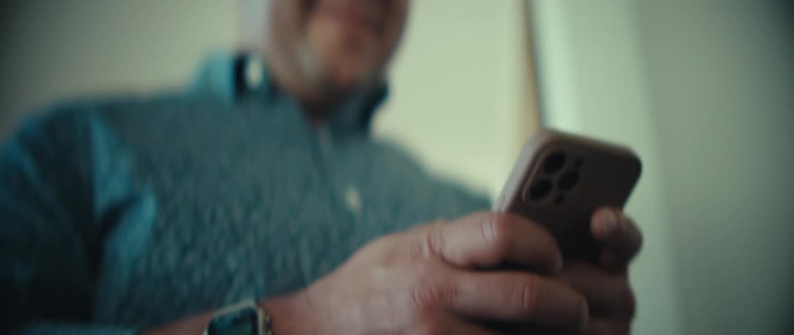 A man using a smartphone while walking in a room