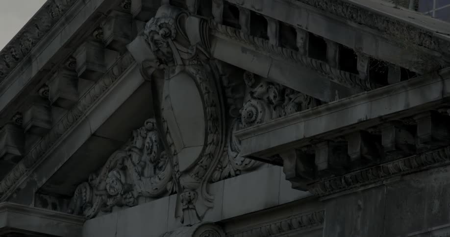 Stone sculptures hang above a building doorway