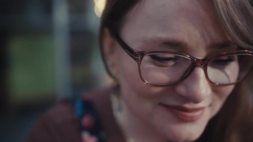 The woman nods her head while listening to something