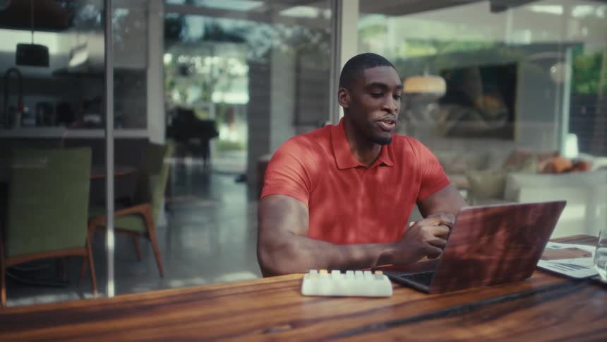 Man sitting and talking on his laptop during a meeting