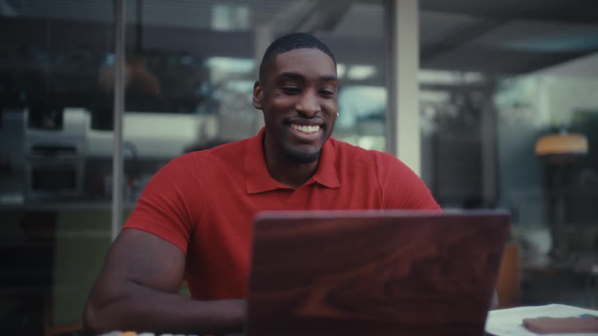 A man using a laptop at a table outdoors