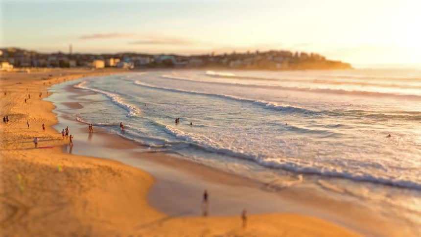 A time lapse of a beach where many people are walking or going into the water