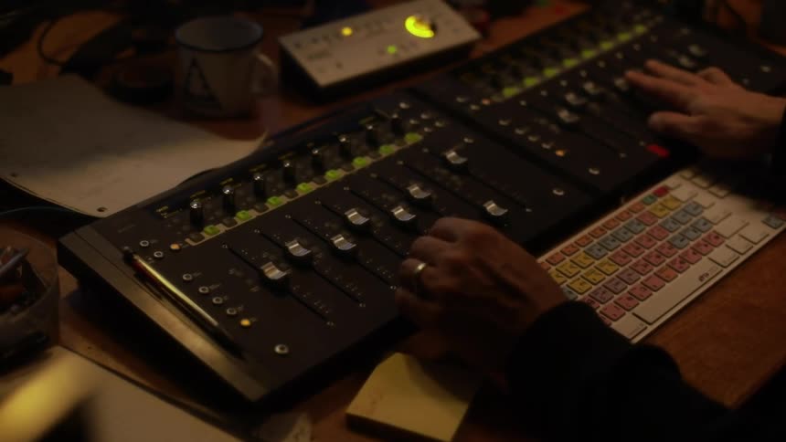 A man using a mixing console in a studio
