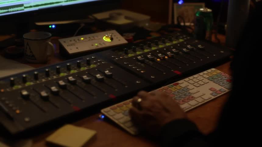 A person using a mixing console in a studio