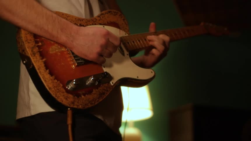 Musician standing as he plays an electric guitar
