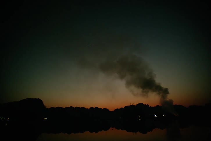 A view of a fire burning in the distance at night