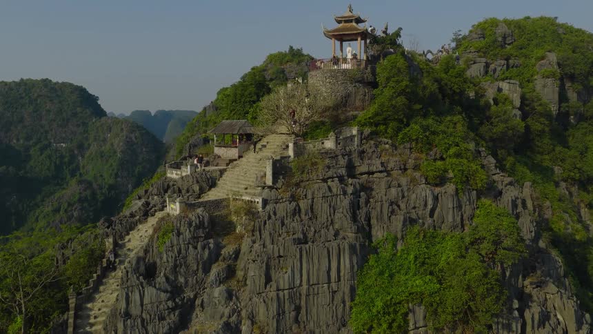 A stairway leads up mountain to a small temple at the top