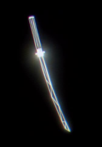 A glowing katana sword stands vertically against a dark void while white light radiates from the blade and hilt amidst digital distortion and scan lines
