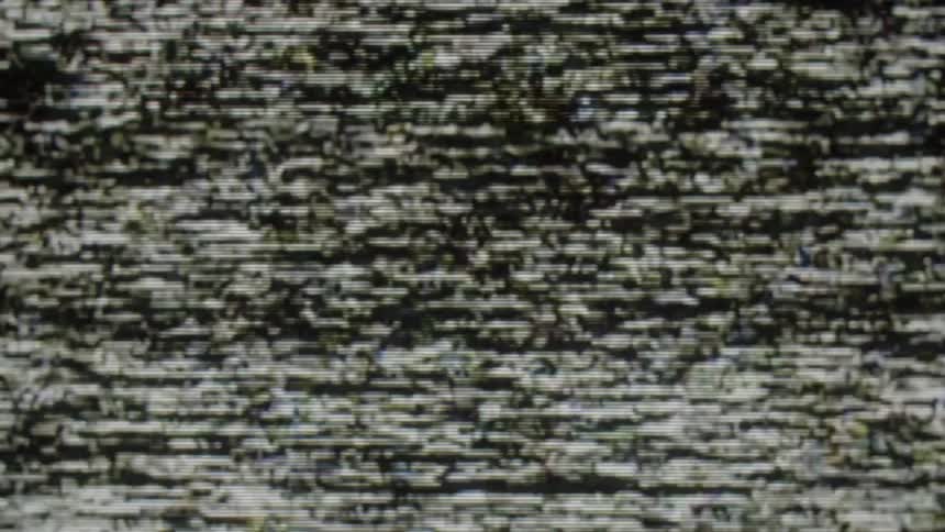A television screen displays heavy analog static and white noise with flickering horizontal tracking lines and grainy distortion across the entire display frame