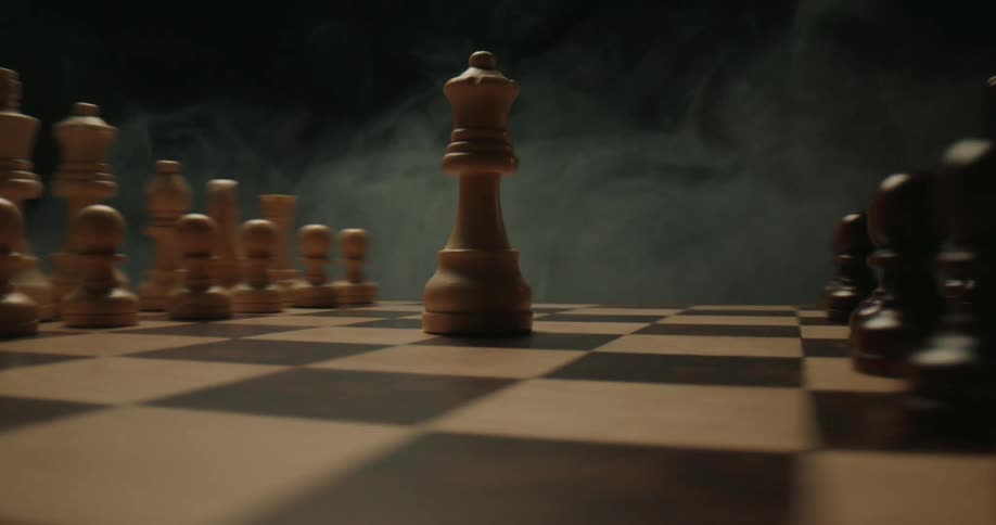 A close view shows a white wooden queen standing in the center of a game board while light smoke drifts across the scene against a dark background