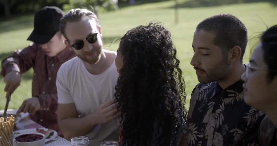 A man kisses a woman at a picnic